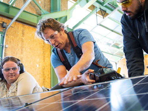 estudiantes y maestro trabajando con energía solar