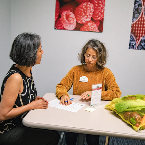 A couple females discussing the program in an office