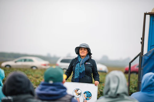 Un instructor en el campo hablando sobre atención médica con los trabajadores