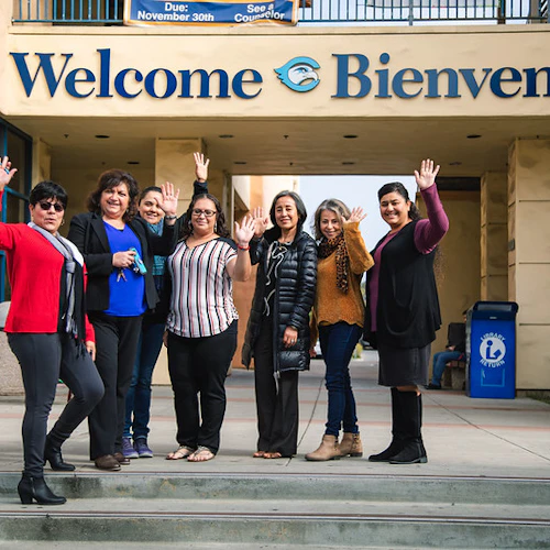Estudiantes e instructores saludando desde los escalones de la escuela