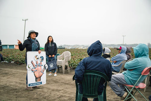 Insturctors speaking with Farms workers on location