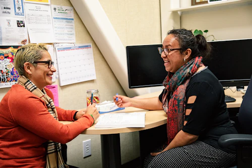 Two people talking at a desk