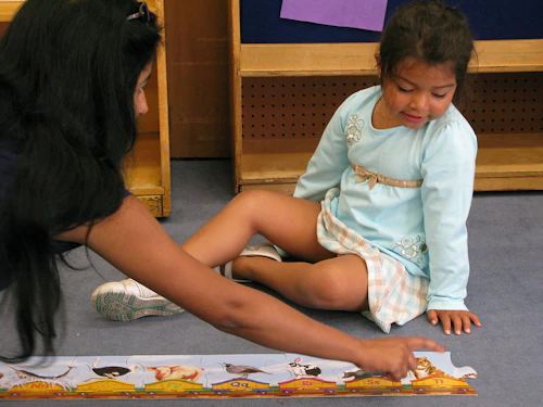 a toddler and teacher are playing