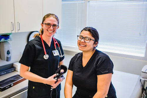 smiling students practicing blood pressure readings