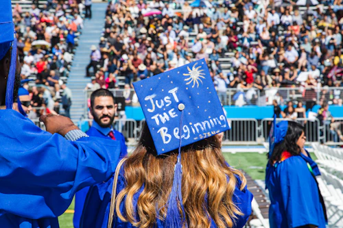 Graduado de Cabrillo College con "Solo el comienzo" escrito en su gorra de graduación.