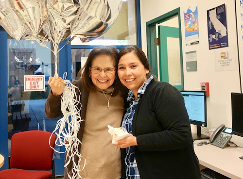 two women holding balloons