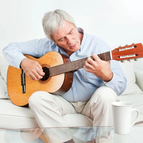 senior man learning to play the guitar