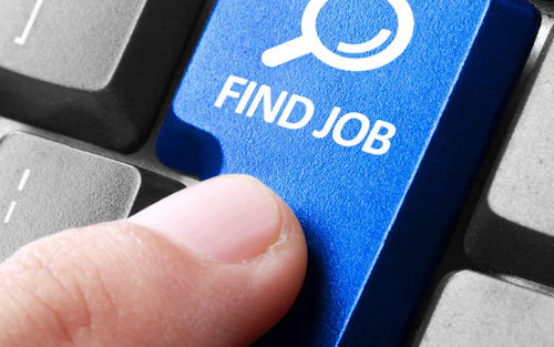 Dedo presionando un botón de buscar trabajo en la computadora.