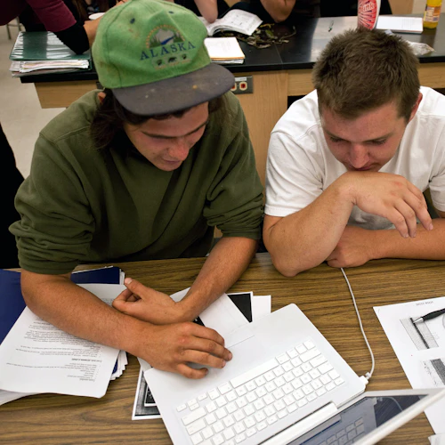 Estudiantes compartiendo laptop