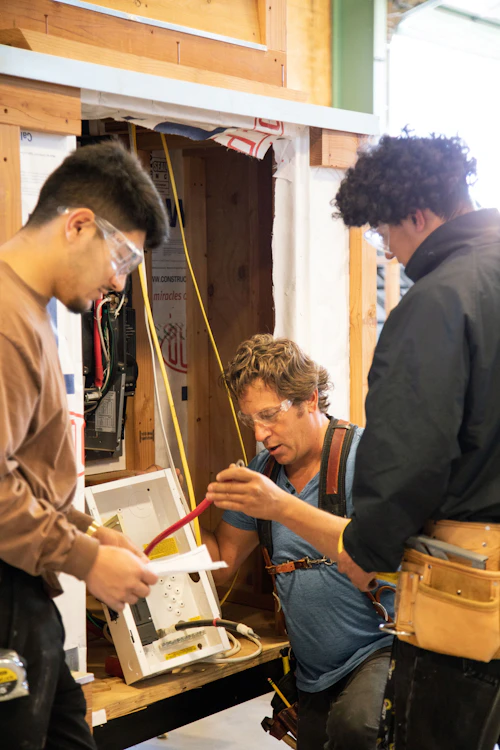 instructor de capacitación en construcción y dos estudiantes