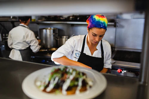 estudiante chef perfeccionando habilidades culinarias en el aula de cocina