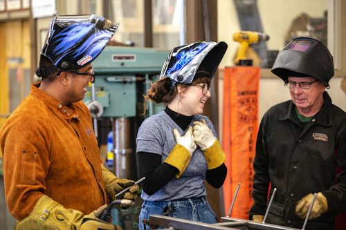 estudiante y profesor de programa de soldadura en aula al aire libre