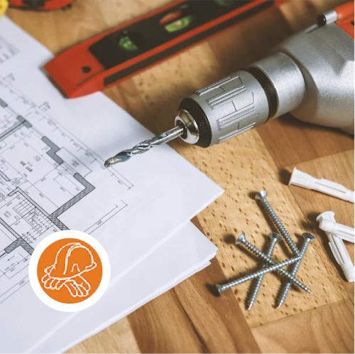 clavos, taladro, nivel y planos de construcción sobre una mesa