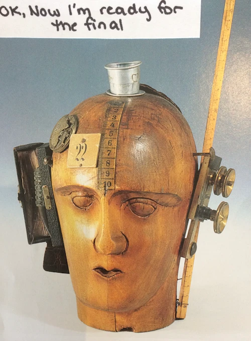 cabeza de madera con regla, hilo