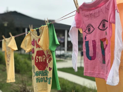 clothesline with several shirts reading "stop domestic violence" and speak up"