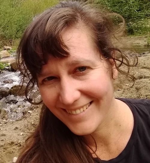 Picture of Emilyn Green with bushes and river in background.