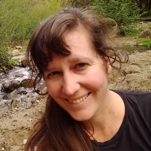 Picture of Emilyn Green with bushes and river in background.