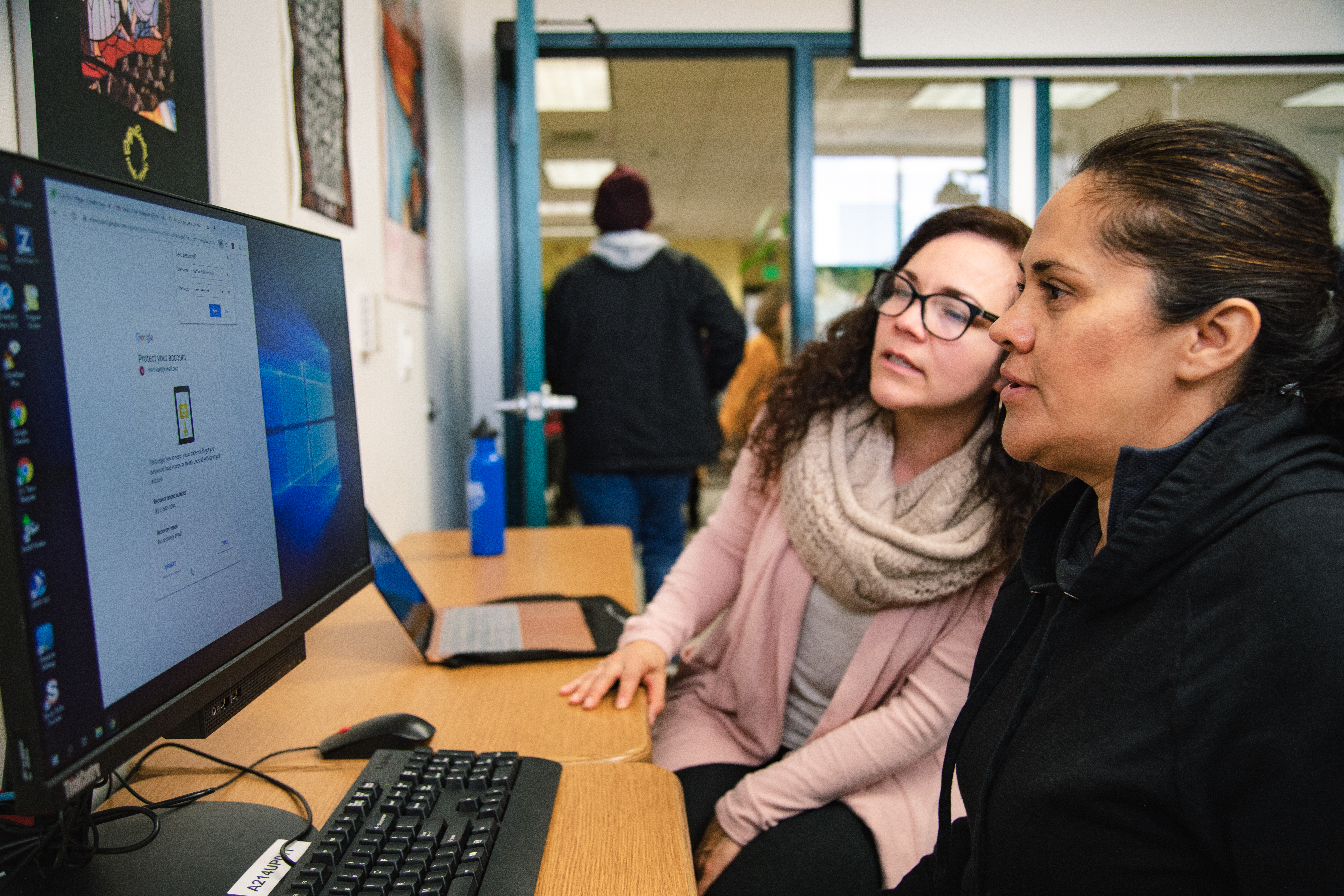 Two women look together at a computer