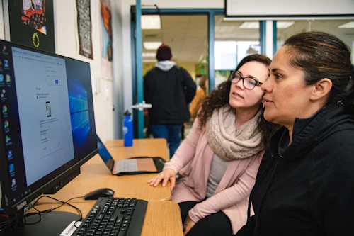 Two women look together at a computer