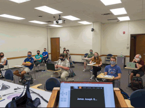 Los estudiantes de Cabrillo College se sientan en escritorios individuales, a seis pies de distancia y con mascarillas puestas.