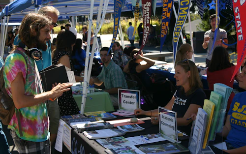 Un estudiante mirando folletos del Colegio Cabrillo sobre una mesa.