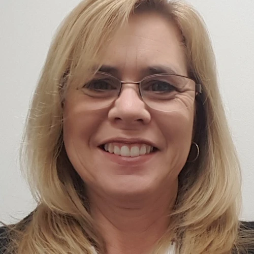 Kim Turner sonriendo con gafas