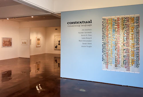 título del espacio de exposición con trabajo en mirol con franjas verticales de letras de letrero