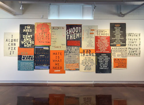 instalación de carteles con citas estampilladas de Trump