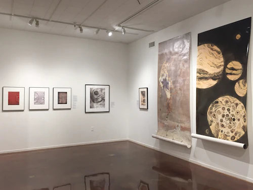 installation view with large lumens hanging off wall as scrolls