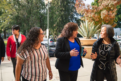 Three women talking and walking