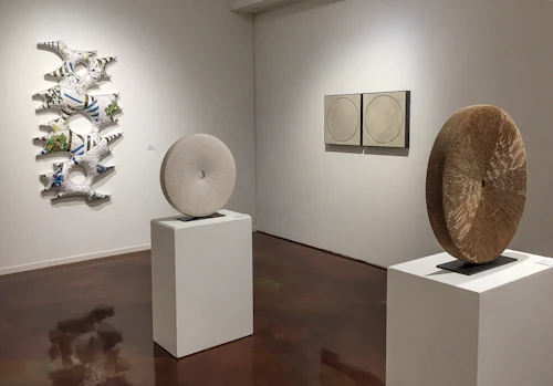 vista de instalación de esculturas de cartón en pedestal y pared