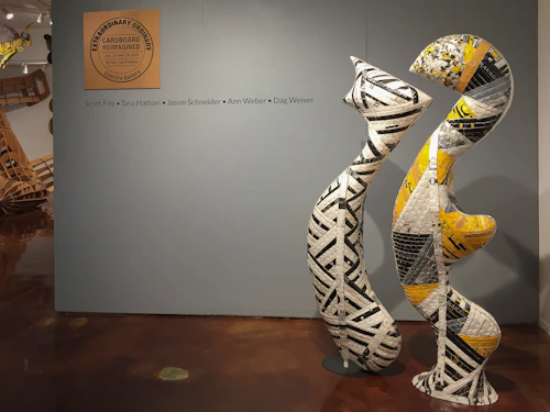 título pared de cartón con figuras orgánicas tejidas de cartón reciclado