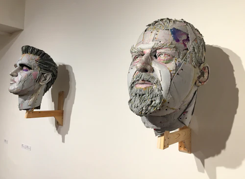 vista cercana de cabezas hechas de cartón en capas que representan a Elvis y Ed Kienholz