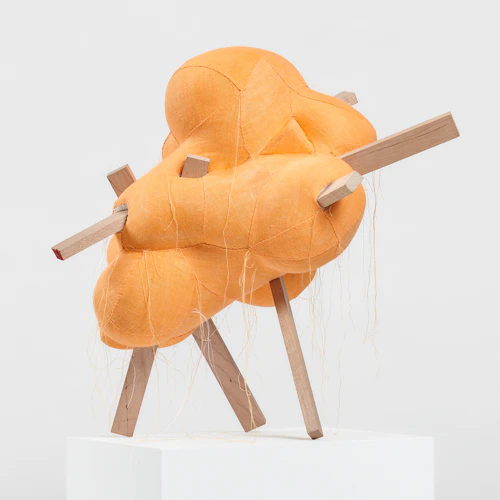 escultura de tela dorada bordada con palos salientes