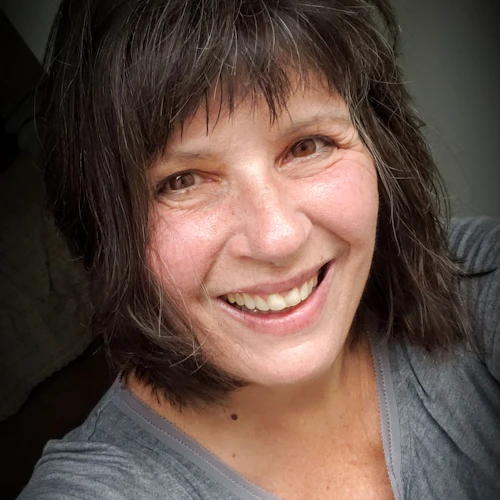 Headshot of a smiling Caucasian woman with short brown hair and brown eyes