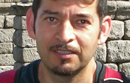 Francisco Iñiguez con el Acueducto Romano de Segovia, España, de hace 2000 años en el fondo. Serie de arcos romanos construidos con enormes bloques de granito convergen en la distancia.