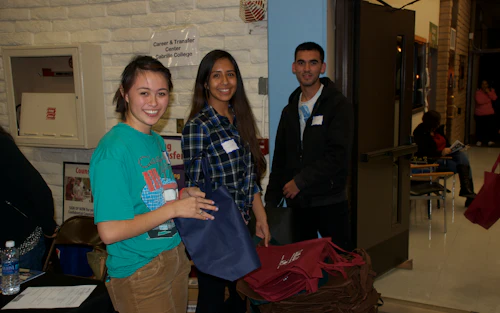 3 smiling students standing in the gym