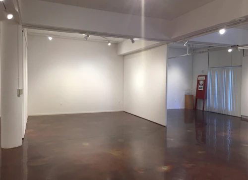Interior of gallery facing front door from opposite back corner