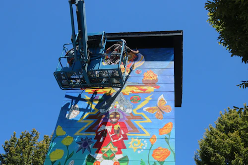Boom lift pintando mural a medio camino