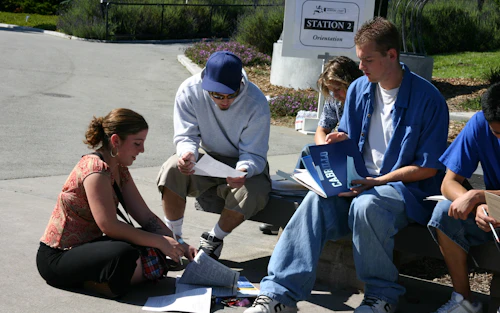 Decorative image: students sitting in the quad planning their classes