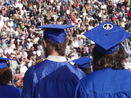 estudiantes caminando en la graduación vistiendo togas azules