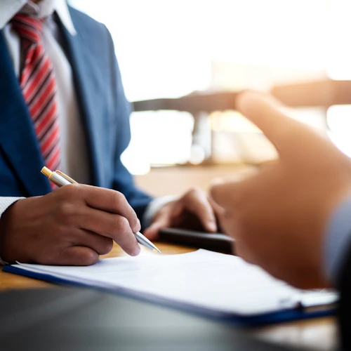 person in suit with pencil and clipboard