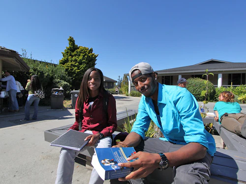 two students sitting in the quad