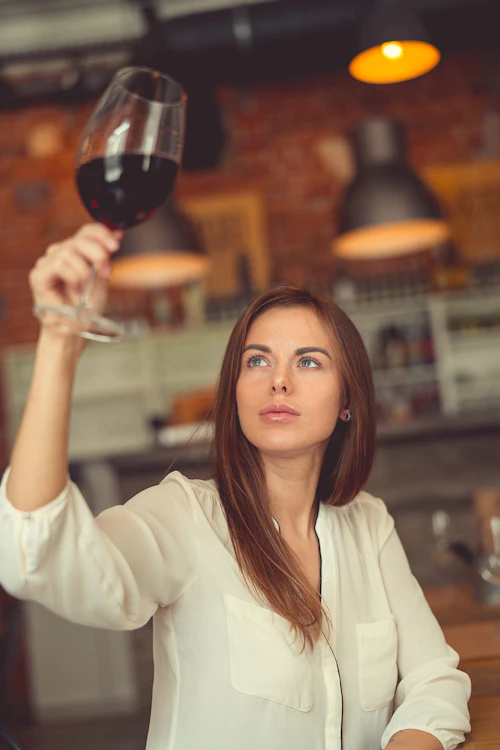 woman studying wine in glass
