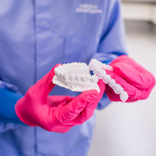 student holding a mold of teeth