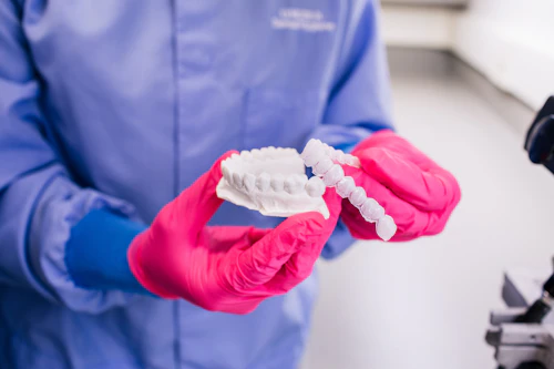 student holding a mold of teeth