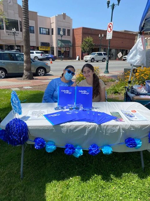 two girls sitting in plaza
