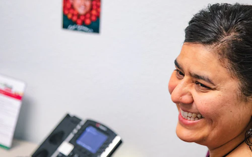 student with a big smile wearing a pink sweater