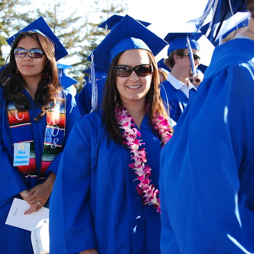 graduados felices caminando en la ceremonia de graduación