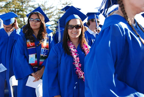 graduados felices caminando en la ceremonia de graduación
